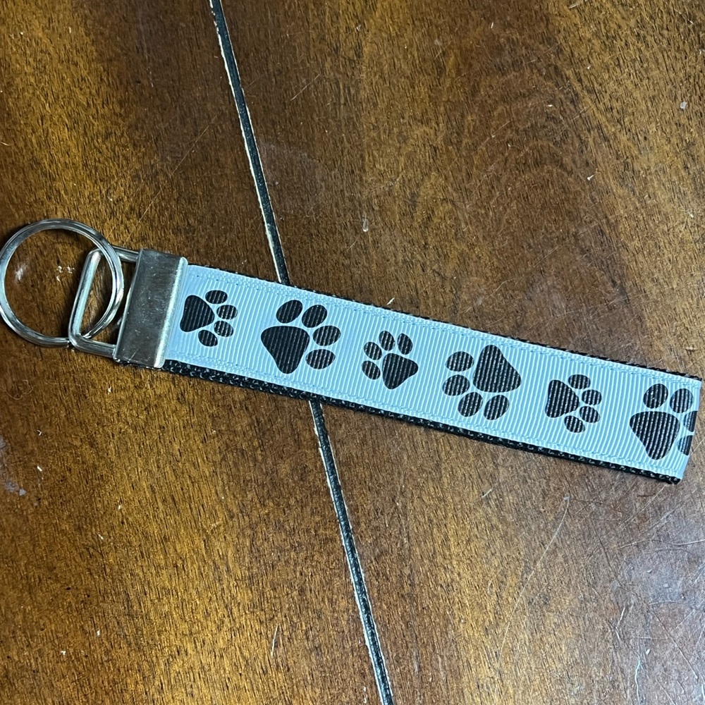 Handcrafted keychain in doggy paws, new without tags.  Ribbon is grosgrain.